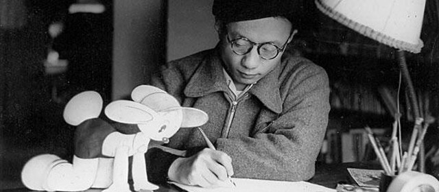 Osamu Tezuka at work accompanied by a cartoon animal