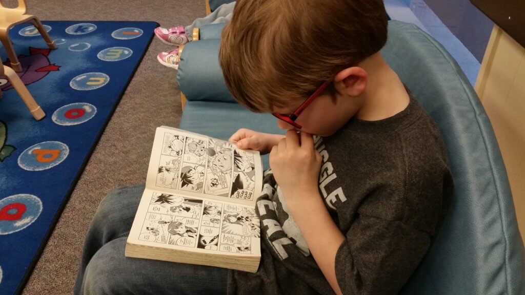 My son reading a Pokemon manga