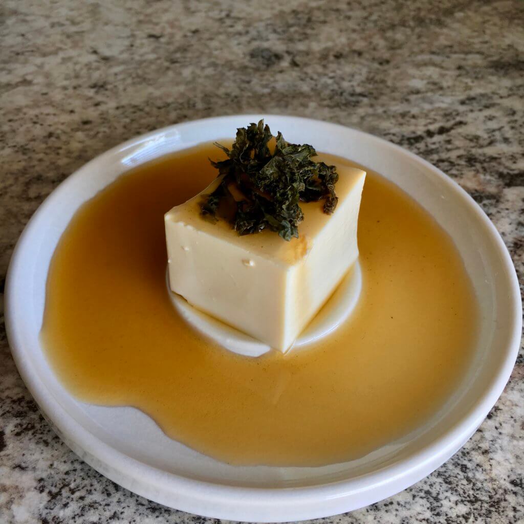 Hiyayakko, or cold silken tofu, displayed in a shallow dish