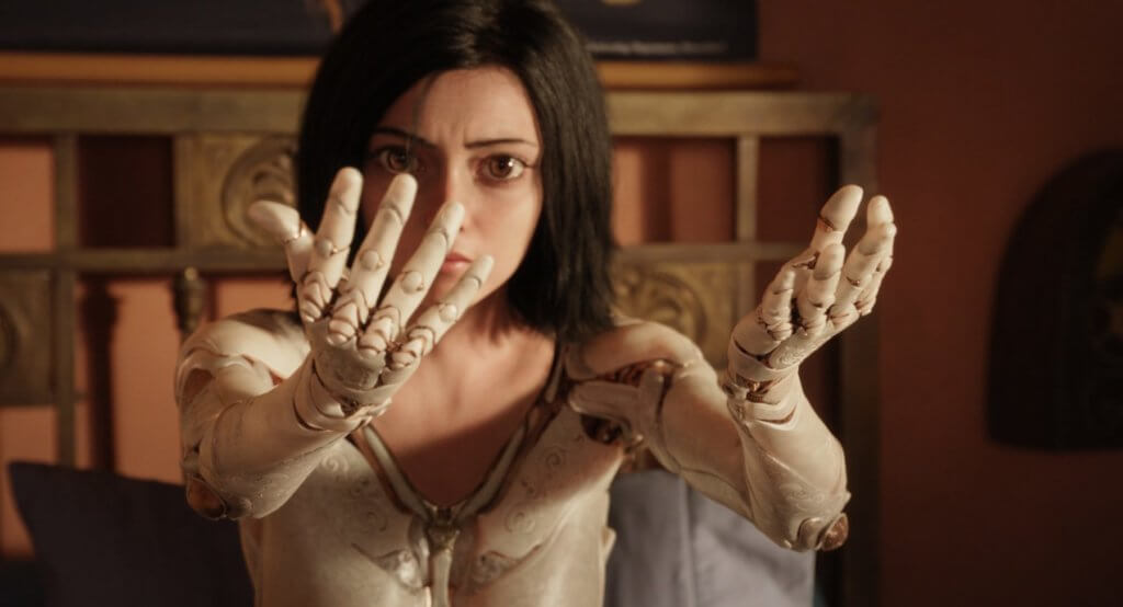 Alita looks at her new arms.