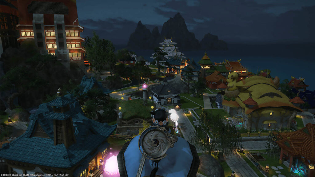 Player is standing in a high place looking down at the Shirogane Housing during night hours.