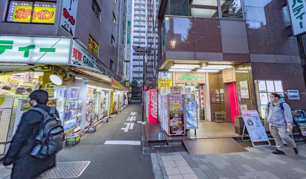 A corner street in Akihabara with vending machines along the right side.