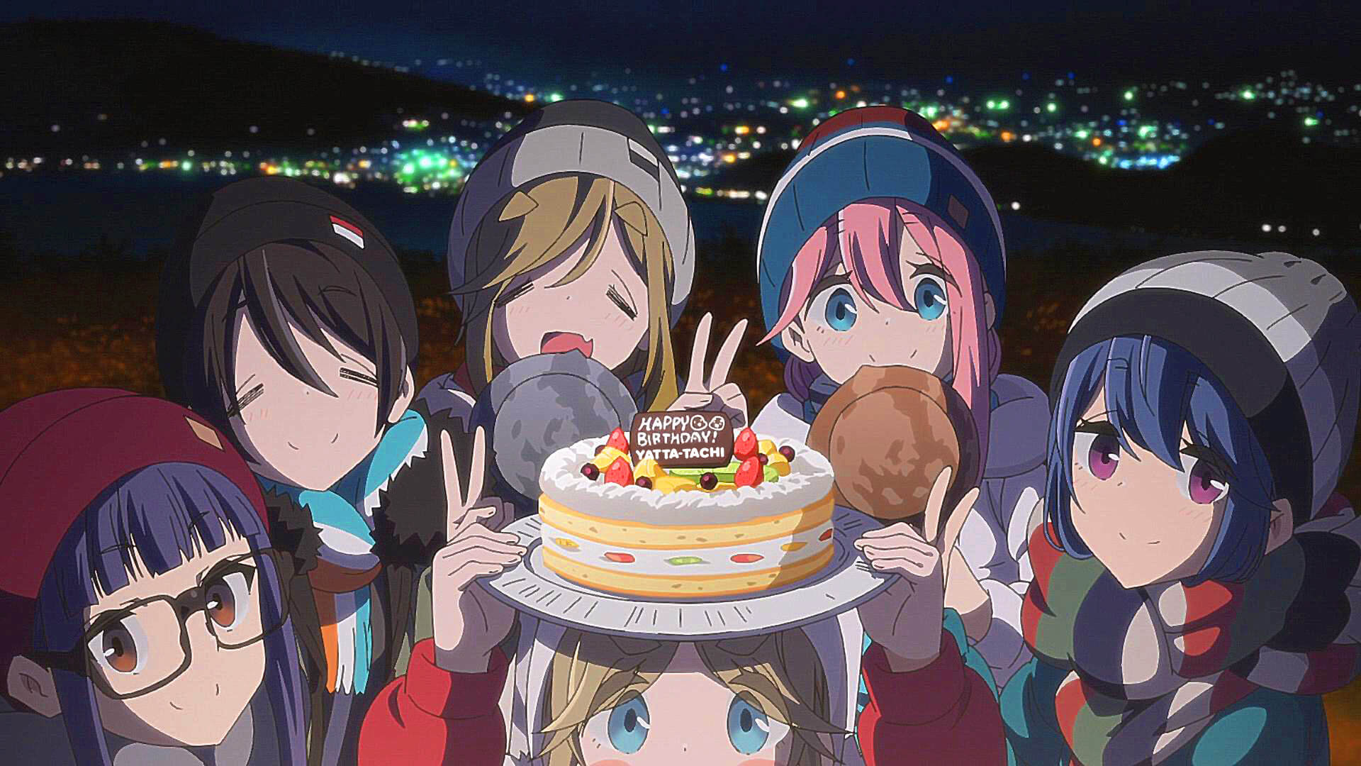 Girls from Laid-Back Camp posing together for a picture and holding up a birthday cake that says "Happy Birthday, Yatta-Tachi!"