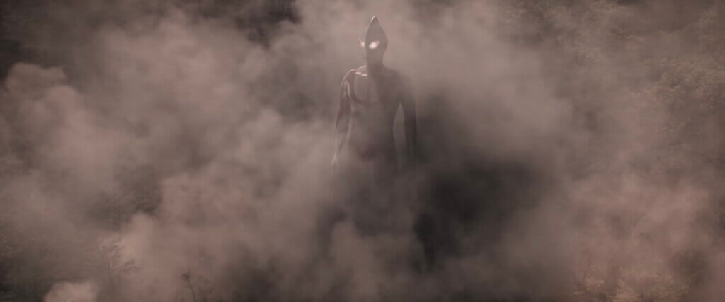 Ultraman surrounded by smoke and debris that came from the ground due to his landing