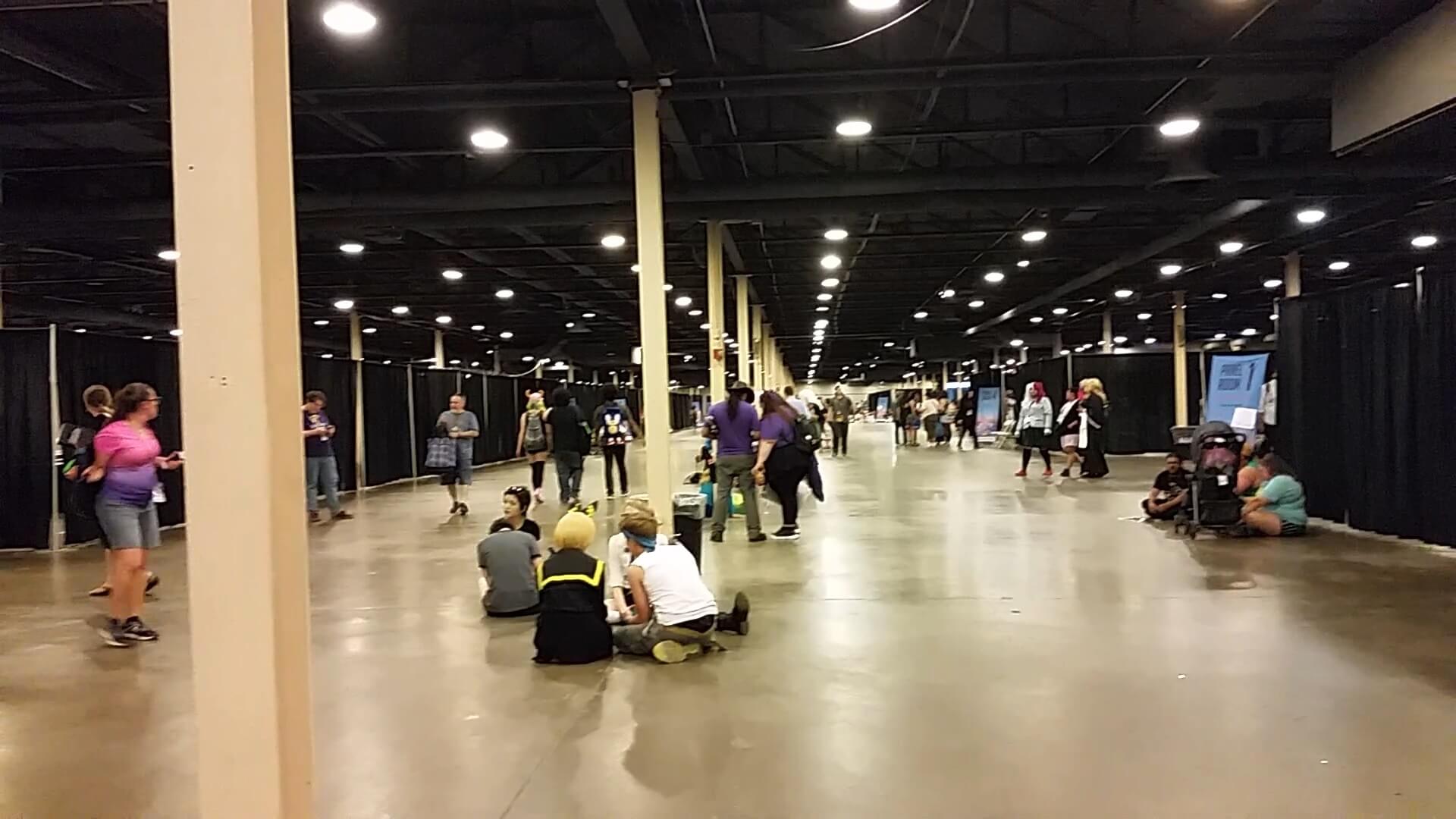 A large hall with several dividers made of fabric being used as makeshift walls