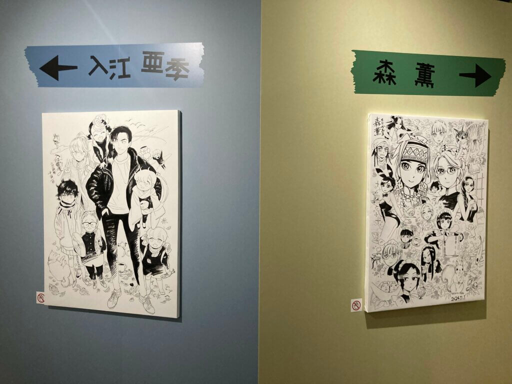 The opening of the exhibit. Arrows point towards Aki Irie and Kaoru Mori’s respective chambers. Beneath both names are poster boards by the authors featuring characters from their respective comics. Irie’s board features figure drawings while Mori’s has faces and busts.