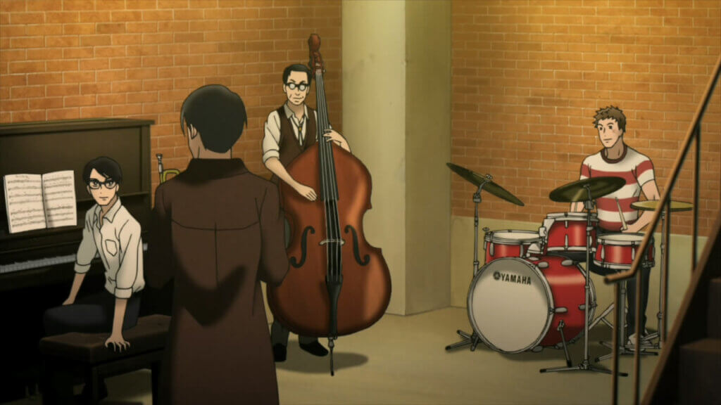 Image is a glasses wearing brunette boy in a white button up sitting at a piano (Kaoru), an older bespectacled gentlemen holding a cello, and a scruffy haired young man in a red and white t-shirt sitting at a drumset. All of them are looking at a black haired man in a suit