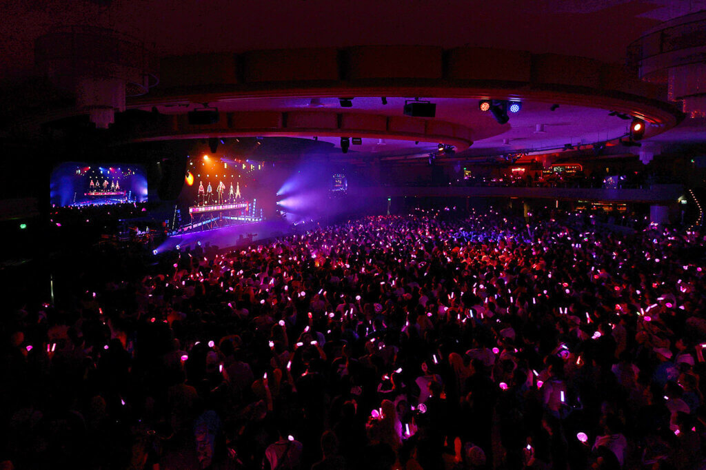 A wide shot of the concert crowd and stage