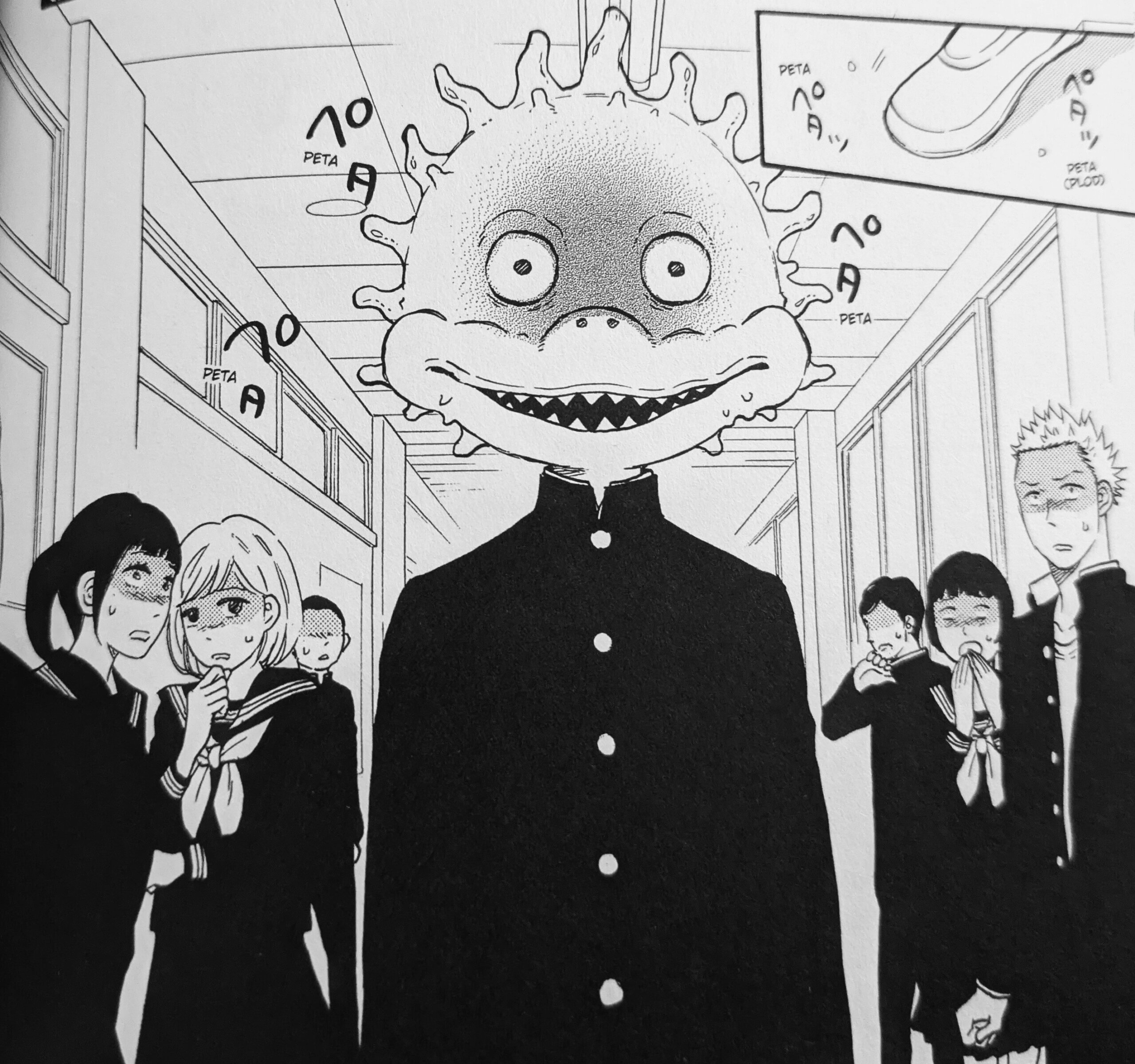 A Japanese high school boy (Arashiro) in a military-style uniform walks through a school corridor. His peers look on at him in horror. He has a head that looks like a giant pufferfish with a giant, goofy, toothy, grin.