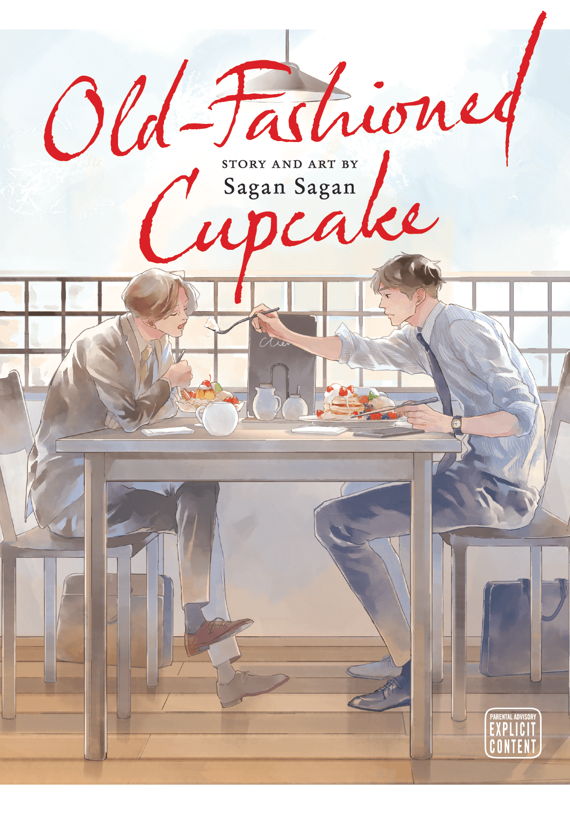 Cover for Old-fashioned Cupcake. Two men sit at a cafe table eating pancakes. The younger man (29) reaches his fork across the table to feed the older man. It has a soft, intimate, sunshine vibe