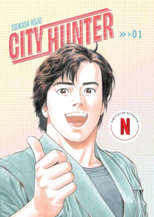 A man with a cheerful expression throws up a thumbs-up at the reader while standing in front of a gradient grid. To his right is a logo reading “A Netflix Live-Action Film.” Above him reads “City Hunter >> > 01” and “Tsukasa Hojo.”