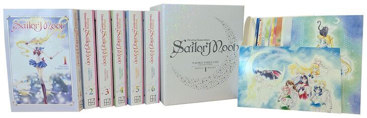 The first volume of the Sailor Moon Box Set, showing six paperback volumes from the Sailor Moon Naoko Takeuchi Collection. The cover of the box set is white, with a gold spot gloss and silver glittery stars. There is a selection of art cards on display, showing famous images from the manga including Usagi, Luna, and the Guardians of the Moon Kingdom, posing together with the Knights of the Earth Kingdom.