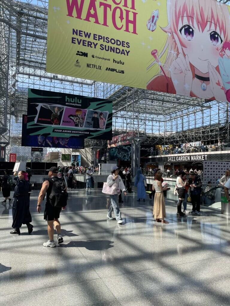 As people walk the floor of the Javits Center, a large banner hangs over them featuring a teenage girl. It reads, "WITCH WATCH: New Episodes Every Sunday."