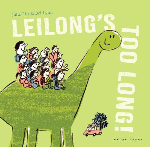 The cover of Leilong’s Too Long!. A grinning, simplified, green brontosaurus has a large group of school children on their back. The car in the background has a tree in it and is significantly smaller than the dinosaur. The title of the book, “Leilong’s Too Long,” is broken up so that “Leilong’s” is across the top, and then “Too Long!” goes downwards, as though bent into place to fit the space.