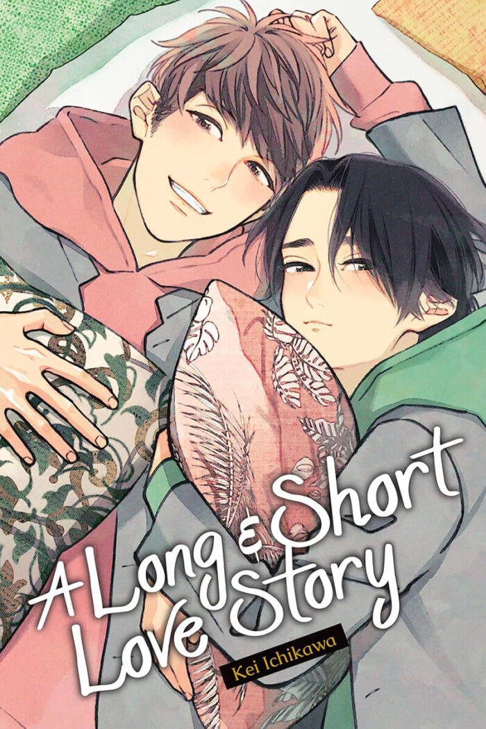 “A Long & Short Love Story” by Kei Ichikawa features Ibuki, a teenage boy with short brown hair next to his neighbor, and eventual boyfriend, Kippei. They are dressed in hoodies and a gray blazer jacket on top. Ibuki wears a pink hoodie, and Kippei is wearing a matching green one. Ibuki is smiling while holding a pillow in one hand, while his other arm is being used as a pillow for Kippei. Kippei, a teenage boy with short black hair, is blushing and pouting while hugging a floral pink pillow to his chest. 