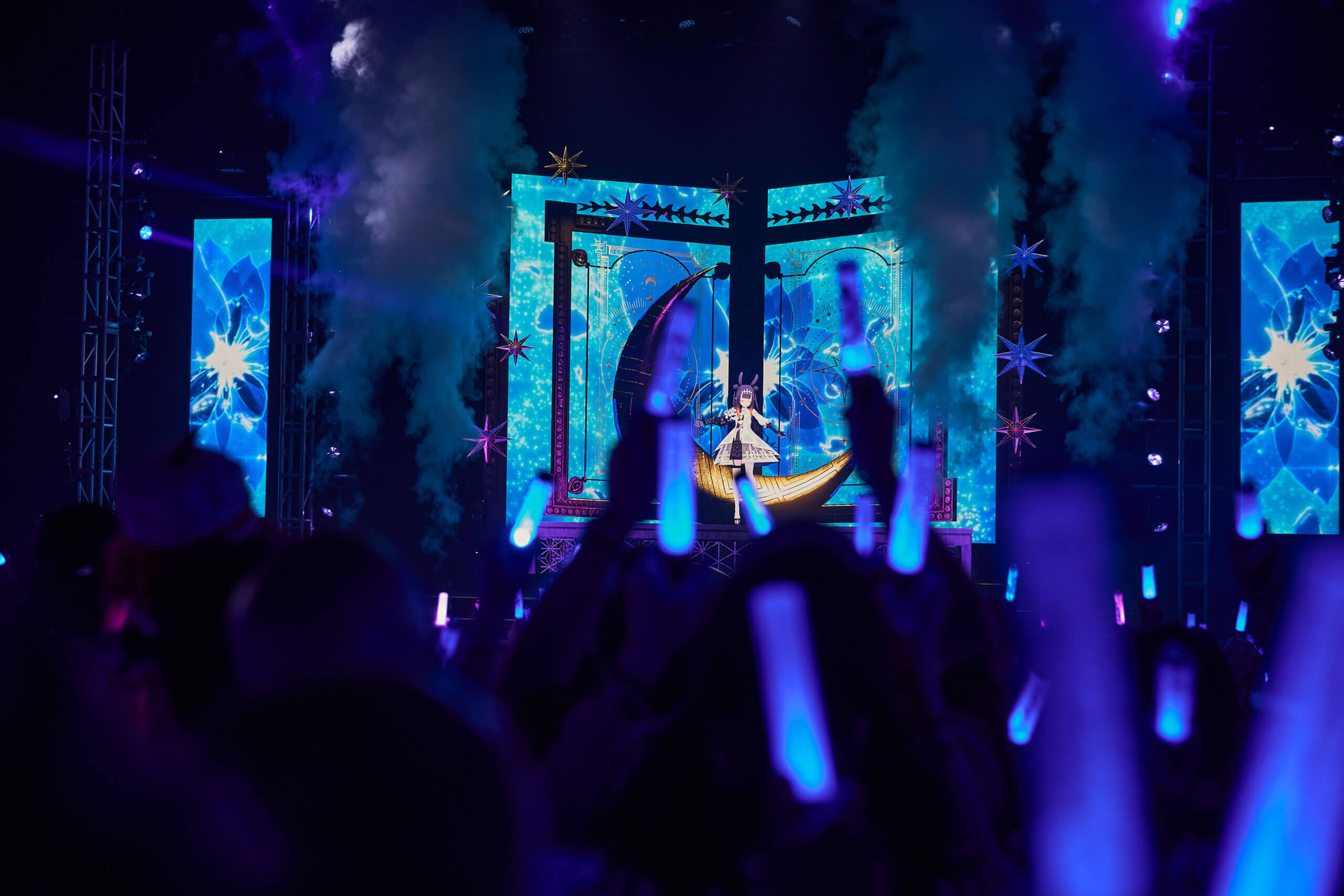 Ina’nis Ninomae performing with a giant crescent moon behind her.