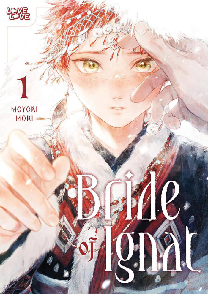 The cover for the manga Bride of Ignat Volume 1 by Moyori Mori featuring the bride Rita. Rita, a young man with short red hair, is dressed in his intricate bride clothes. He stands in the winter cold as a large hand is gently brushing his fur-lined hood away from his face. Large dragon scale earrings hang from Rita’s ears, blowing in the blizzard wind.