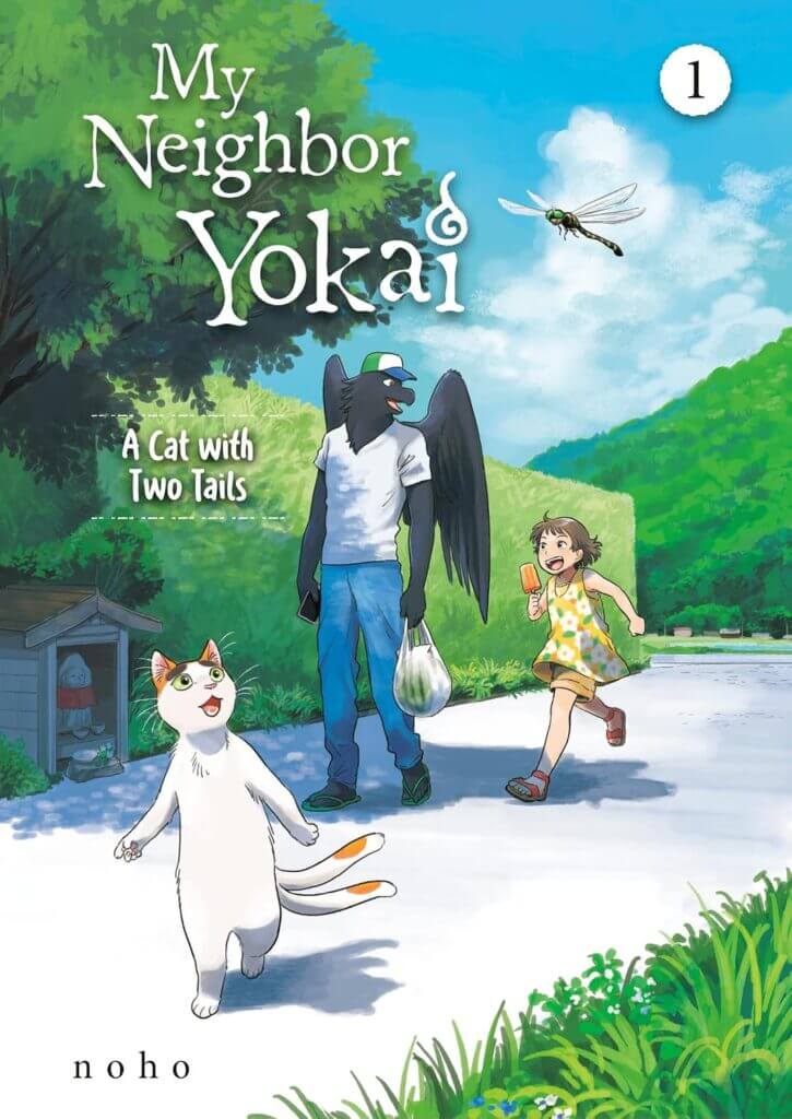 The cover of My Neighbor Yokai, depicting a two-tailed cat walking on its hind legs, a crow man, and a young girl walking down a town road bordered by green grass and a hedge. A small shrine can be seen under a tree on the left.