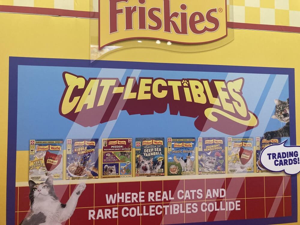 The outside of the Friskies booth. It reads: “Cat-lectibles: Where Real Cats and Rare Collectibles Collide.”