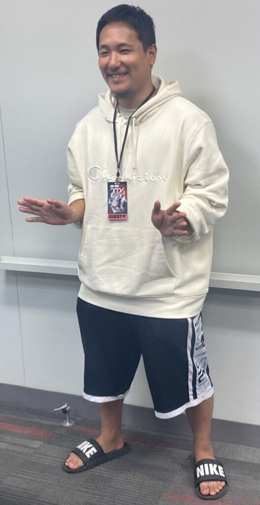 A photo of Mokochan. He is wearing a hoodie and Nike flip-flops.